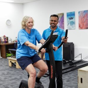 Patient on the bike during an osteoarthritis physio appointment as part of her GLA:D program